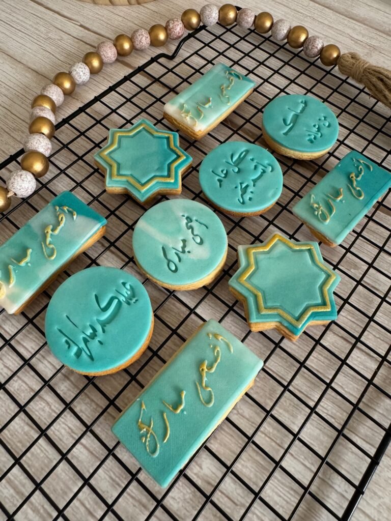 A beautiful assortment of custom Eid Mubarak cookies by Hala Cookies, featuring elegant teal and gold icing with Arabic calligraphy, ideal for Eid al-Adha and festive celebrations in Doha.