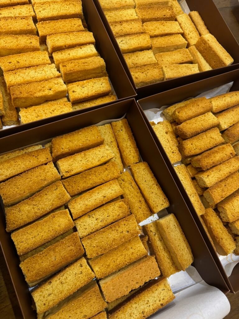 Boxes filled with freshly baked traditional rusk biscuits by Hala Cookies, a crunchy and comforting treat perfect for dipping in tea during family gatherings in Doha.